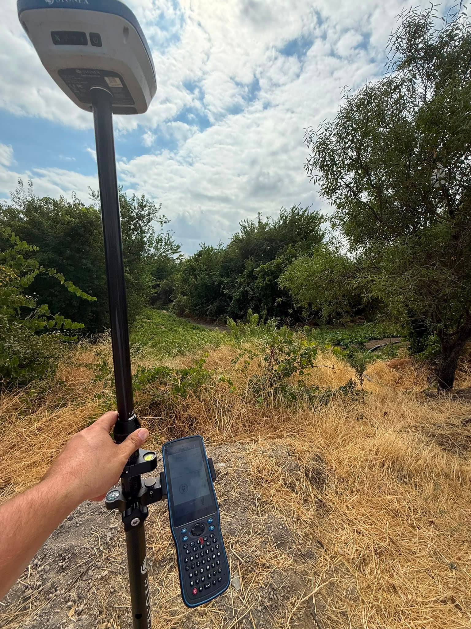 Dere kenarındaki arazide GNSS direğiyle nokta ölçümü alınması